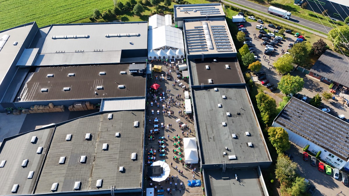 Luftaufnahme des REMKO-Werksgeländes in Lage mit Gästen, Tischen und Festzelt zwischen den Hallen.