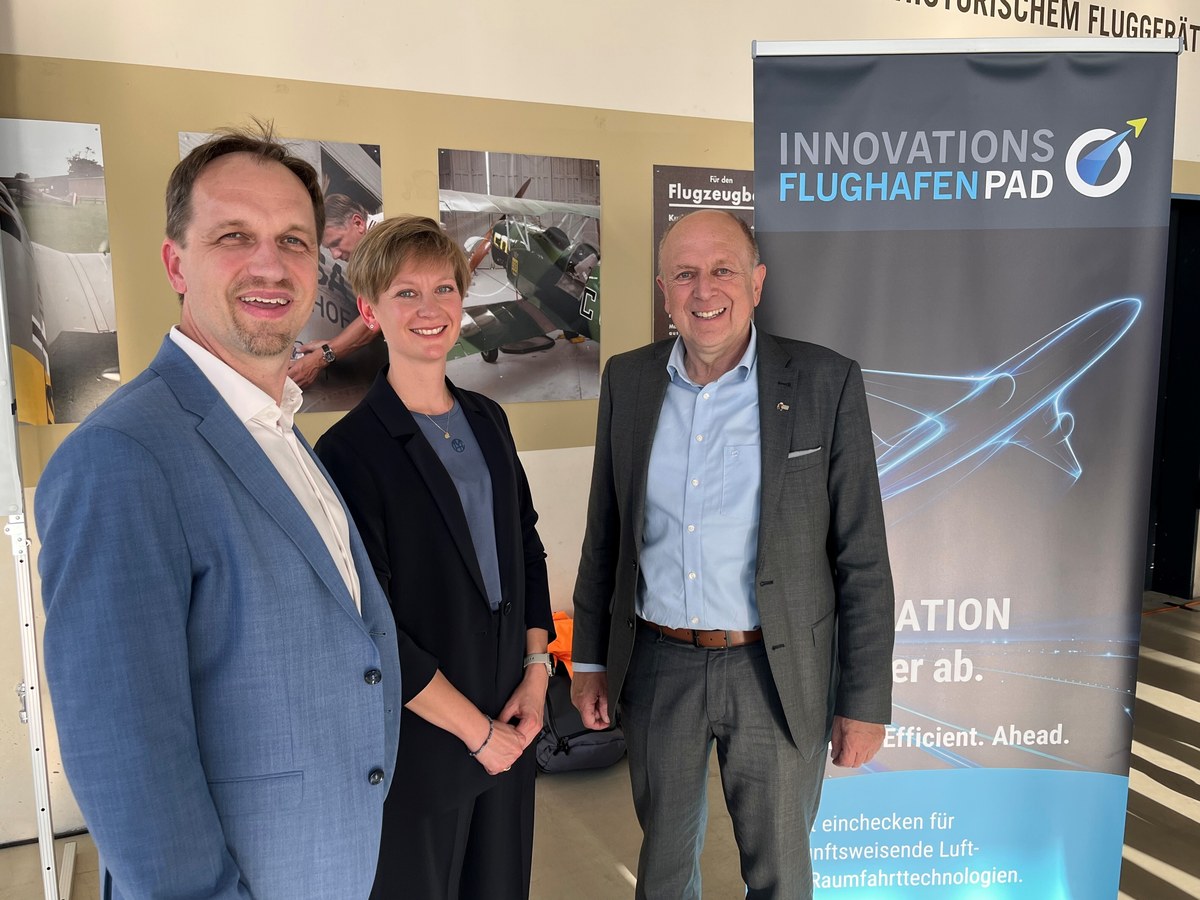 Drei Vertreter des Innovationsflughafens PAD und von GATE vor einem Banner der Initiative